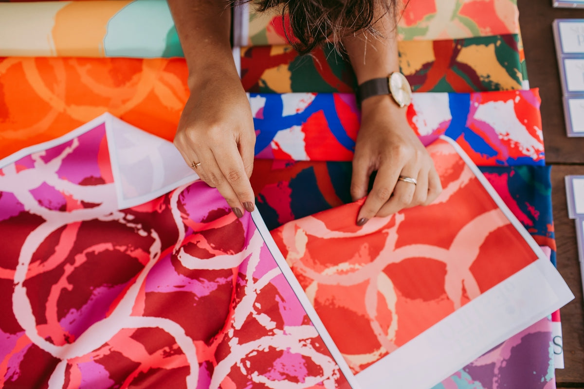 person holding red and white floral textile