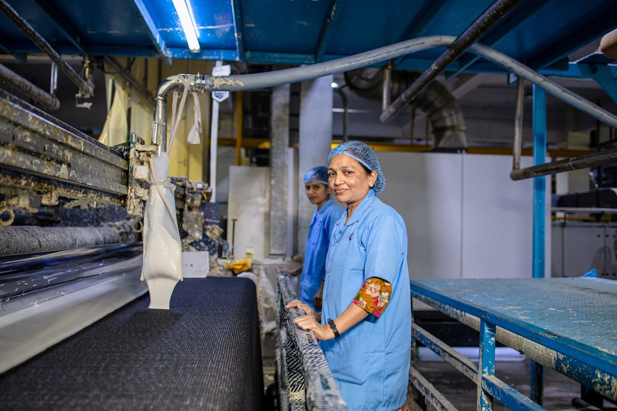 Workers inspect fabric at a textile factory.