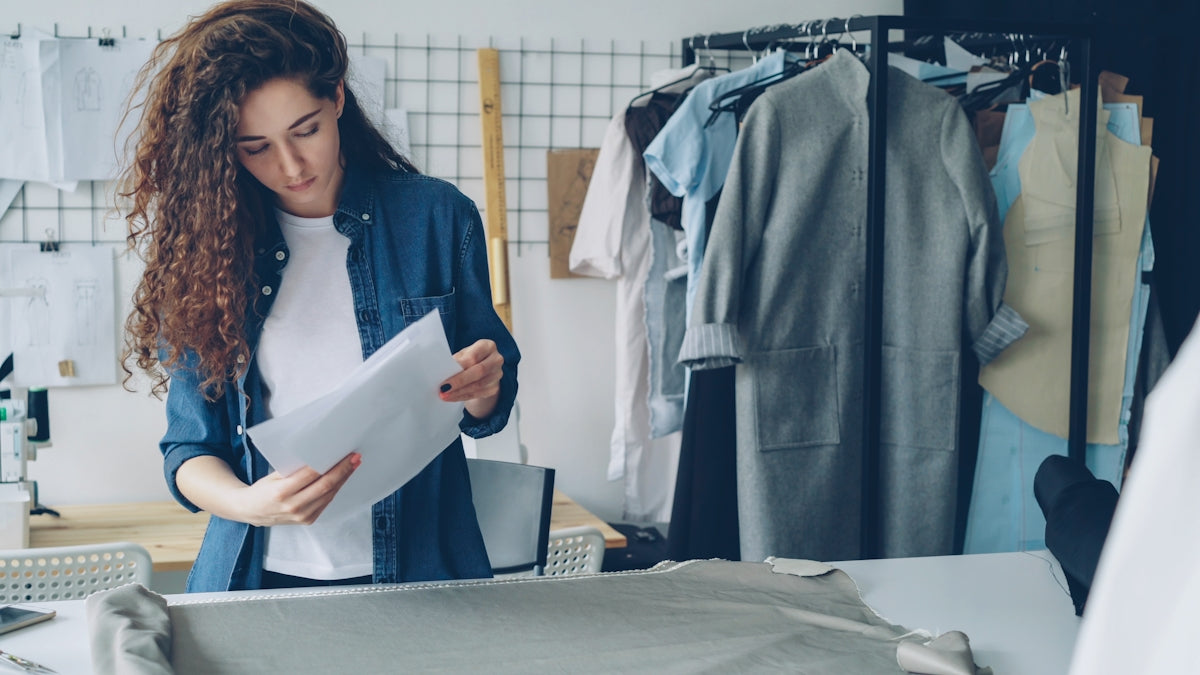 A seamstress reviews designs in her studio.