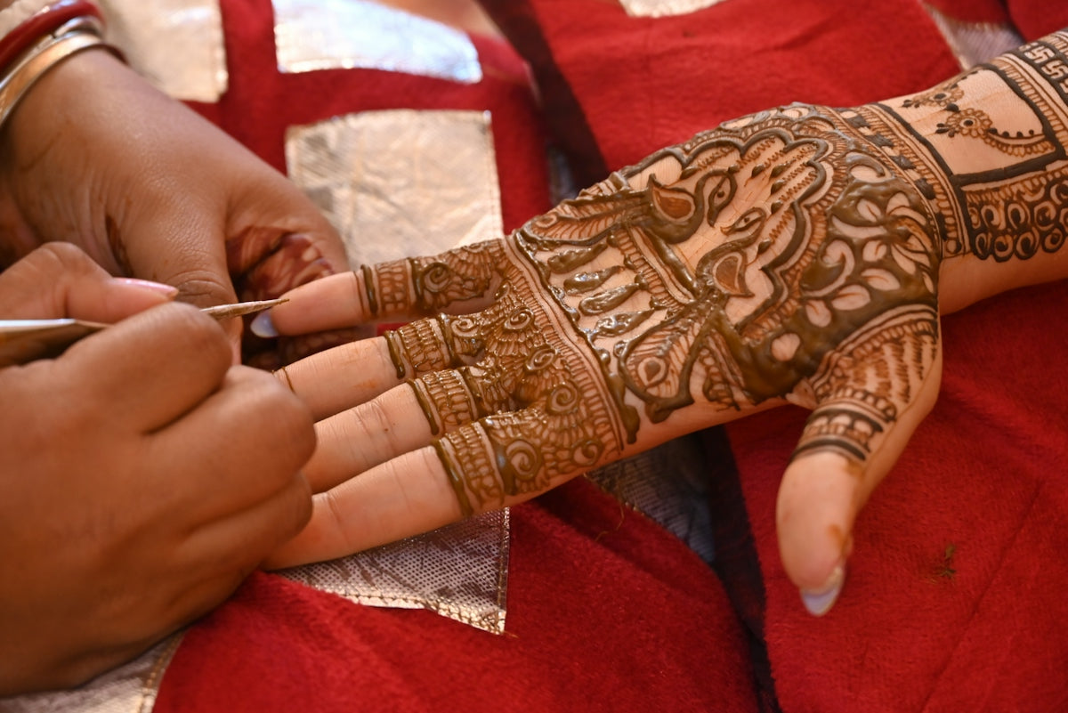Artist applying intricate henna design to hand