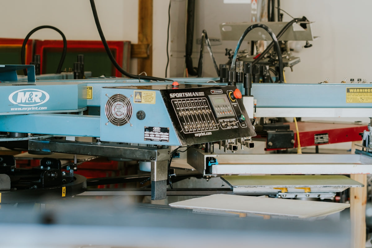 Industrial screen printing machine in a workshop setting.