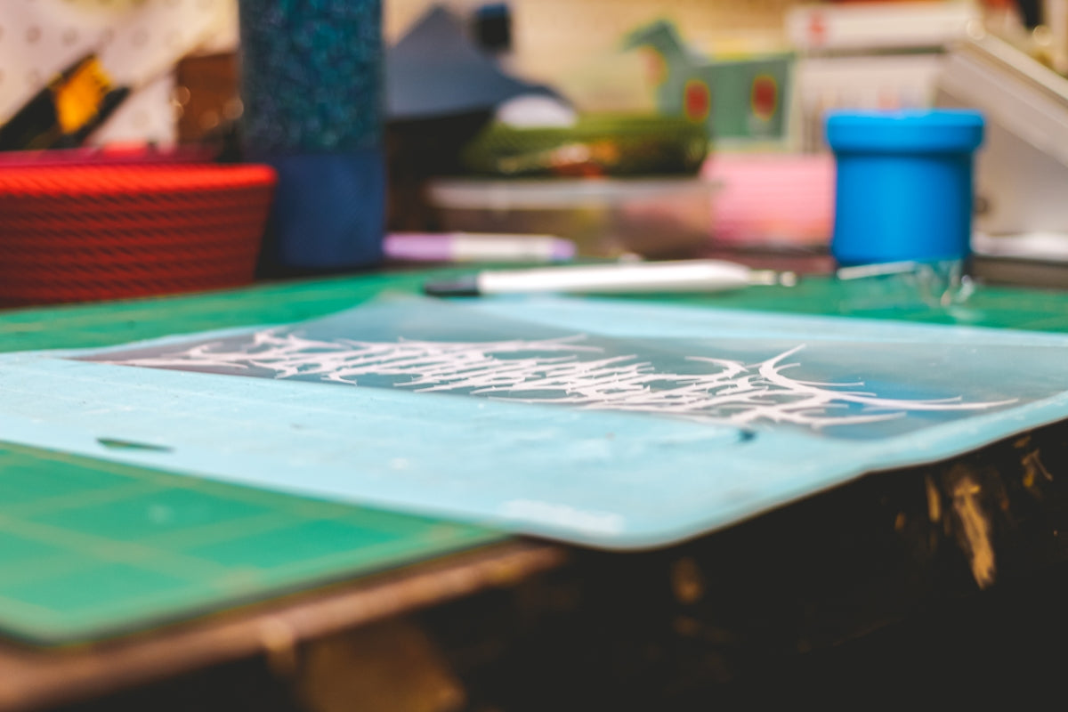 Close-up of a cutting mat with various crafting supplies.