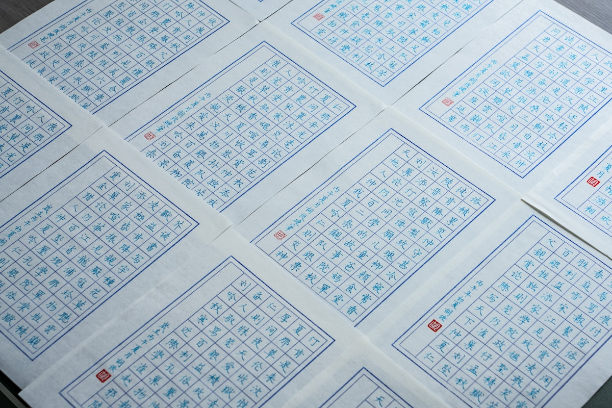 Gridded sheets of paper with chinese characters and red stamps.
